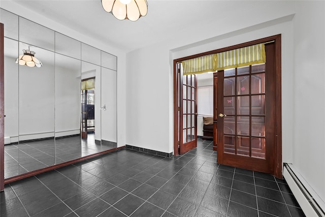 unfurnished room featuring dark tile patterned floors, baseboards, a baseboard heating unit, and a baseboard radiator