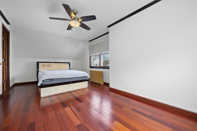 bedroom featuring radiator, baseboards, vaulted ceiling, and hardwood / wood-style flooring