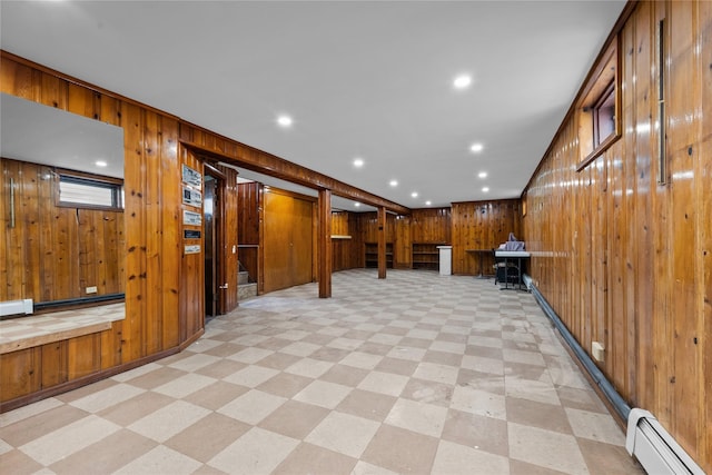finished basement with wooden walls, recessed lighting, baseboard heating, and light floors