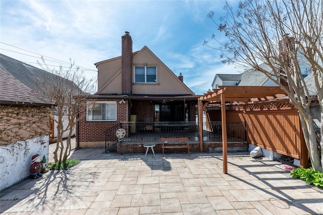 back of house with a pergola, brick siding, a chimney, a patio, and fence private yard