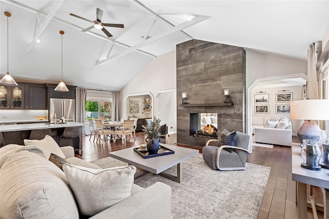 2307 Hawthorne Dr, Yorktown Heights, NY 10598 - living room with arched walkways, wood finished floors, a ceiling fan, a multi sided fireplace, and high vaulted ceiling