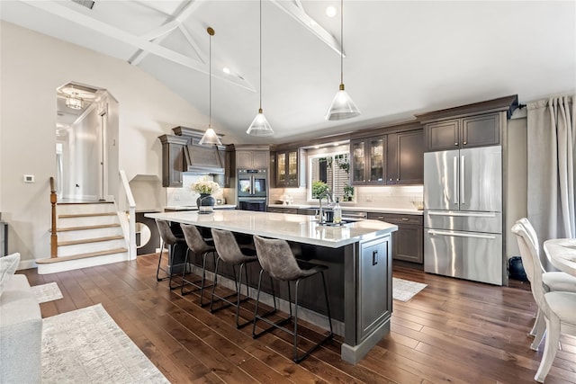2307 Hawthorne Dr, Yorktown Heights, NY 10598 - kitchen featuring appliances with stainless steel finishes, light countertops, dark wood finished floors, glass insert cabinets, and tasteful backsplash