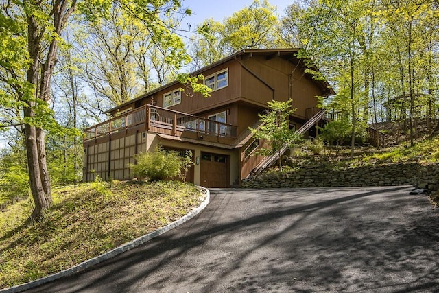 view of front of property with a garage, stairs, and driveway
