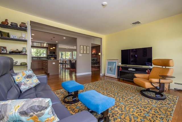 living area with visible vents and wood finished floors