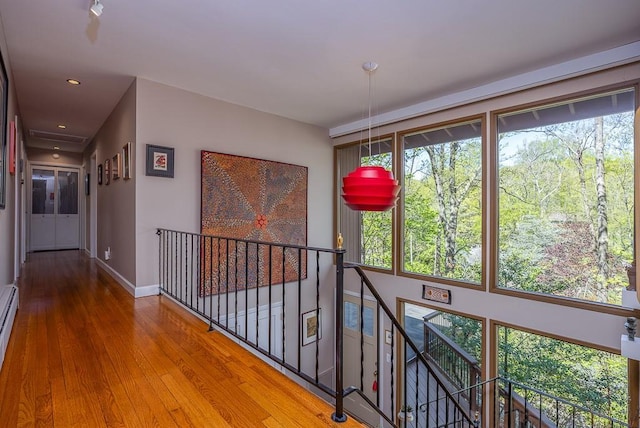 hall featuring baseboards, recessed lighting, wood finished floors, and an upstairs landing