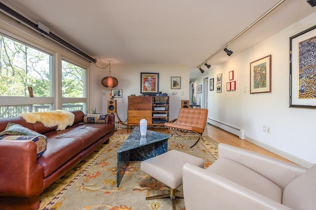 living room featuring track lighting, a baseboard radiator, and wood finished floors