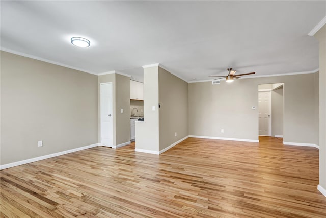 265 Artist Lake Dr, Middle Island, NY 11953 - unfurnished living room featuring crown molding, baseboards, ceiling fan, light wood-type flooring, and a sink