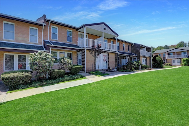 265 Artist Lake Dr, Middle Island, NY 11953 - townhome / multi-family property featuring a residential view, a balcony, a front lawn, and brick siding