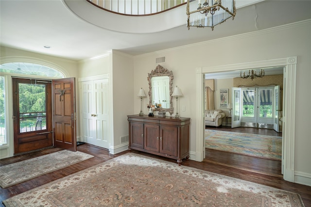 entrance foyer featuring an inviting chandelier, wood finished floors, and a healthy amount of sunlight