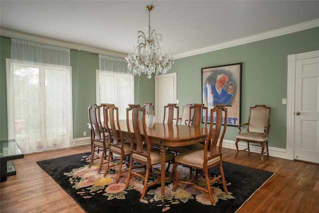 dining room featuring crown molding, baseboards, a notable chandelier, and wood finished floors