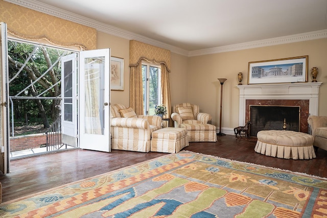 living room with ornamental molding, wood finished floors, and a high end fireplace