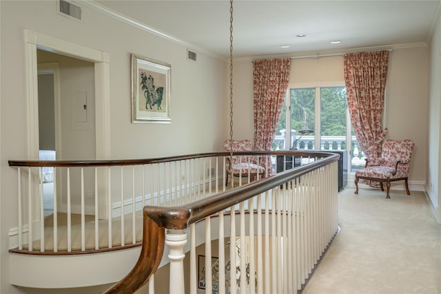 hallway featuring light colored carpet, visible vents, and ornamental molding