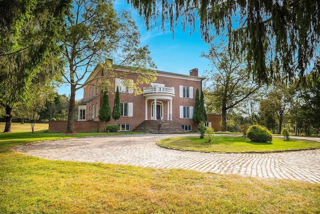 604 N Quaker Hill Rd, Pawling, NY 12564 - view of front of home featuring a balcony, a chimney, a front lawn, and brick siding