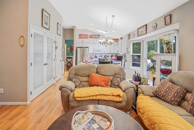 138 Barton Ave, Patchogue, NY 11772 - living room featuring a chandelier, vaulted ceiling, light wood-style flooring, and french doors