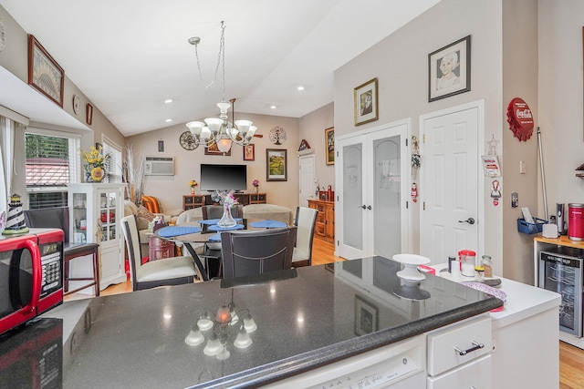 138 Barton Ave, Patchogue, NY 11772 - kitchen with wine cooler, light wood-style floors, lofted ceiling, a chandelier, and white cabinetry
