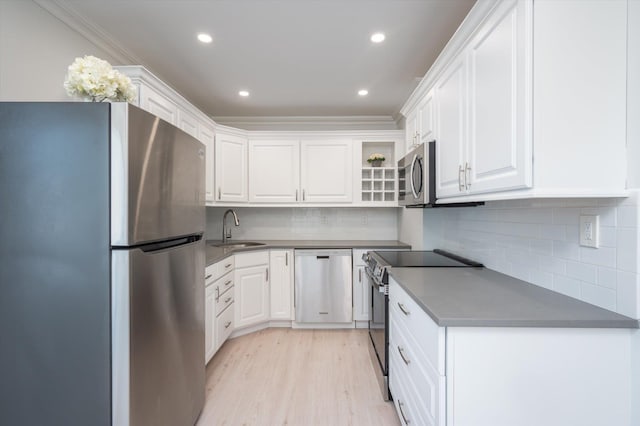 kitchen featuring a sink, appliances with stainless steel finishes, and white cabinets