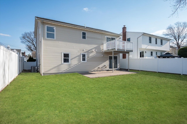 rear view of house featuring a yard, a fenced backyard, a patio area, and a balcony