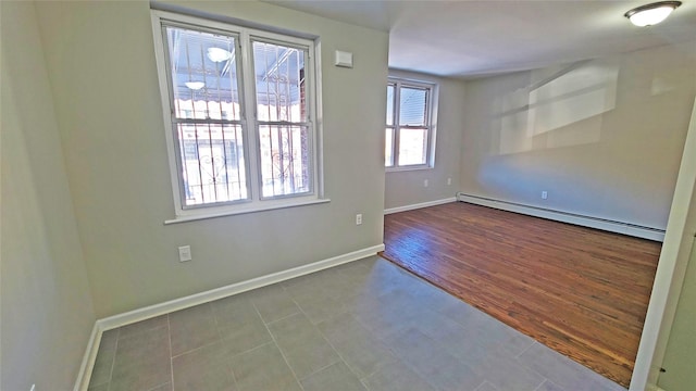 unfurnished room featuring baseboards and a baseboard heating unit