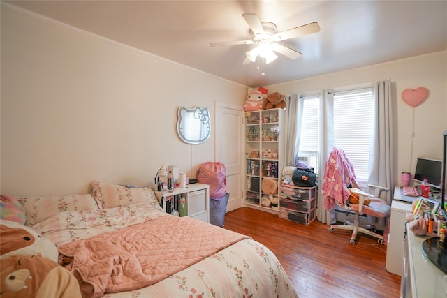 bedroom with crown molding, ceiling fan, and hardwood / wood-style floors