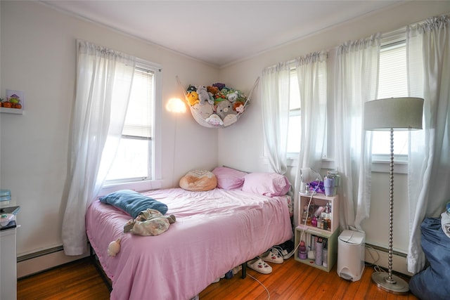 bedroom featuring a baseboard radiator and wood finished floors