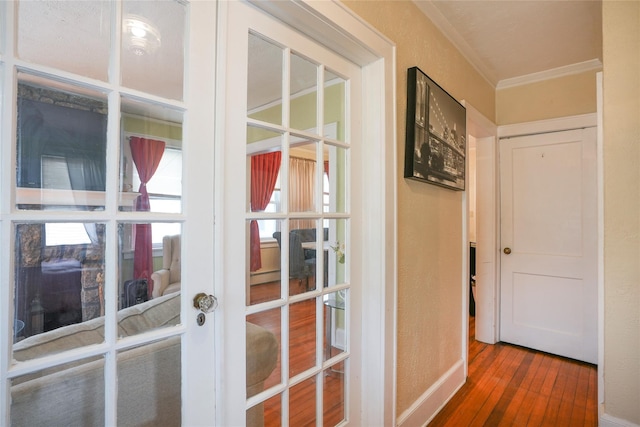 entryway with crown molding, wood-type flooring, baseboards, and french doors