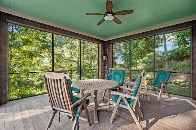 sunroom / solarium featuring a ceiling fan and outdoor dining area