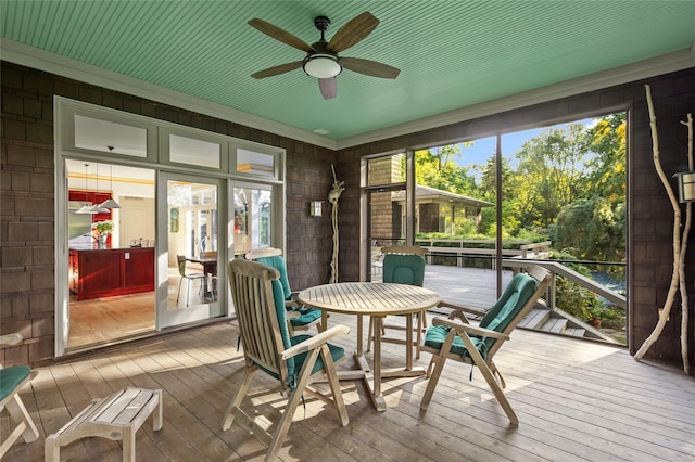 sunroom featuring outdoor dining area and ceiling fan