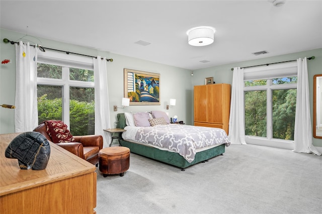bedroom with multiple windows, carpet flooring, and visible vents