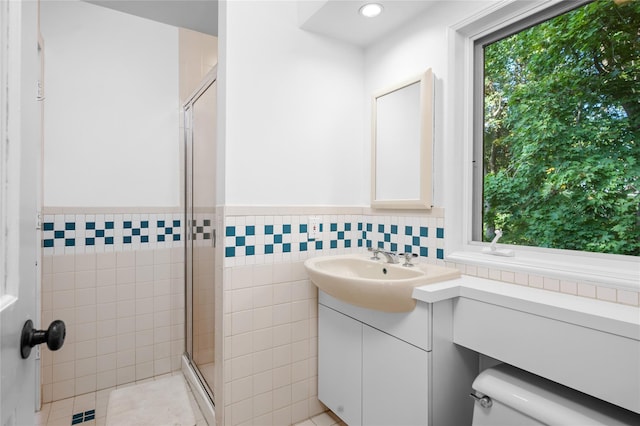 bathroom featuring vanity, tile walls, a wainscoted wall, and a stall shower