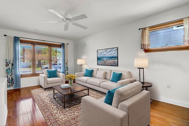 living room with baseboards, ceiling fan, and wood finished floors