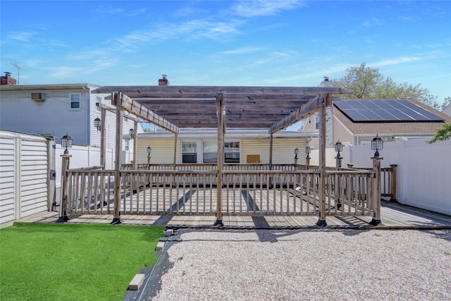 rear view of property with a pergola, a wooden deck, a fenced backyard, and a patio area