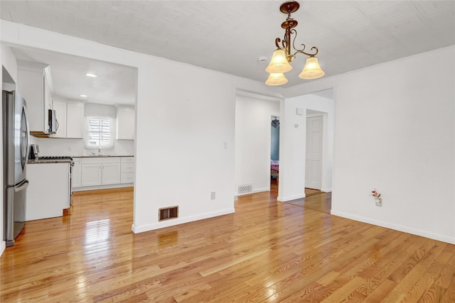 14-46 142nd St, Whitestone, NY 11357 - unfurnished dining area with light wood-style floors, a chandelier, a sink, and baseboards