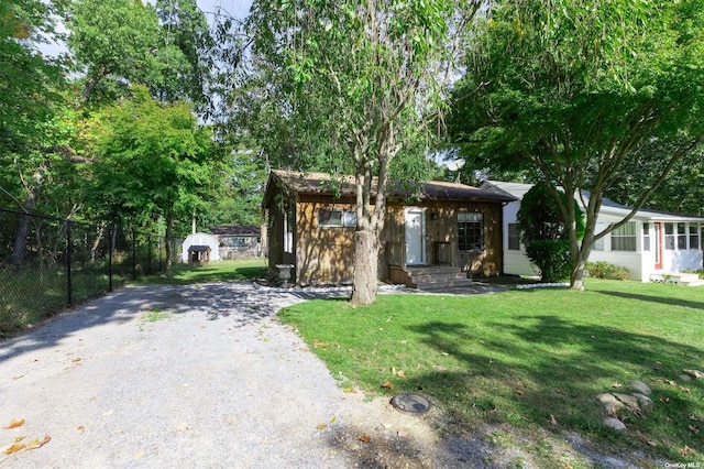 view of front of property featuring a front lawn and gravel driveway