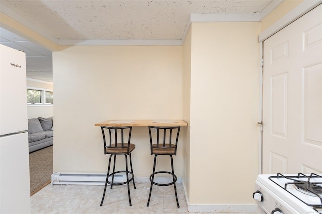 dining space featuring baseboards, a baseboard heating unit, and a drop ceiling