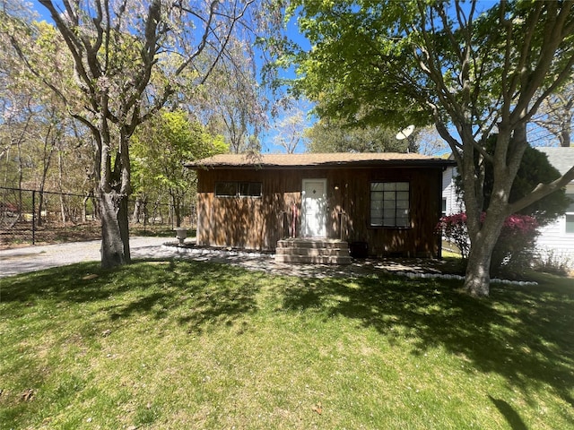 view of front of house featuring board and batten siding, fence, and a front yard