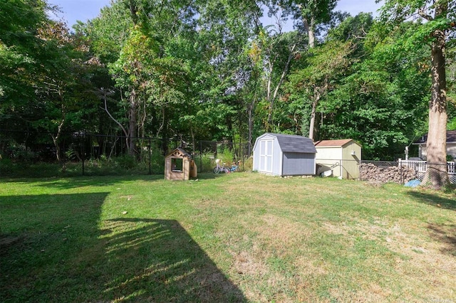 view of yard featuring a storage shed, an outdoor structure, and a fenced backyard