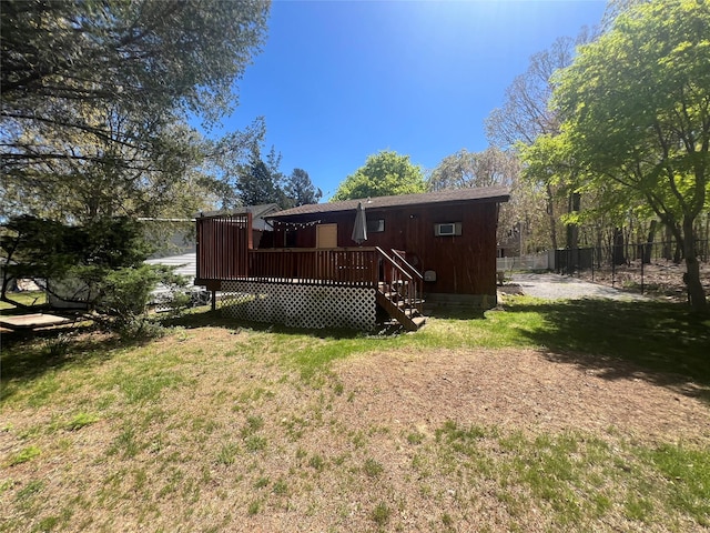 back of property with a yard, fence, and a wooden deck
