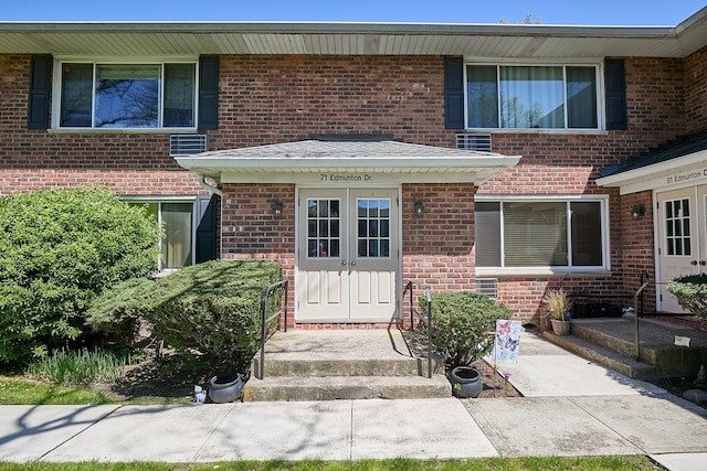 view of front of house with french doors, central air condition unit, and brick siding
