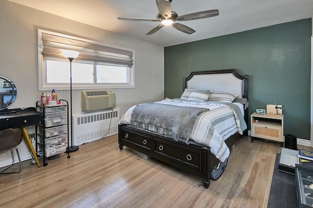 bedroom featuring wood-type flooring, a ceiling fan, and radiator heating unit