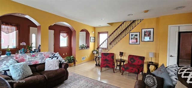 living room featuring visible vents, stairs, wood finished floors, baseboards, and recessed lighting