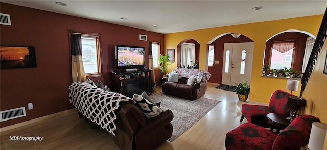 living room with visible vents, recessed lighting, and wood finished floors