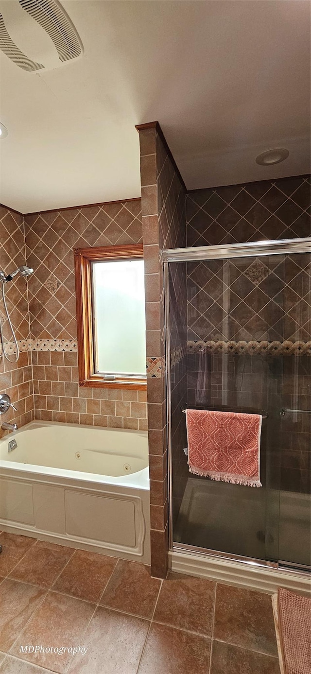 bathroom with tile patterned floors, a shower stall, a bath, and visible vents