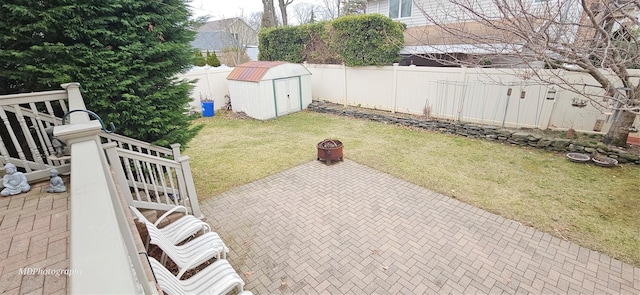 view of yard featuring a storage shed, a patio, an outdoor structure, and a fenced backyard