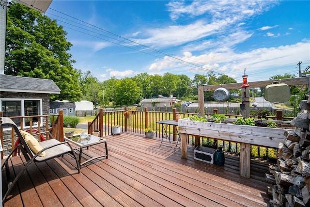 wooden terrace with an outdoor structure and fence