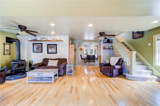 living room with ceiling fan, wood finished floors, and stairway