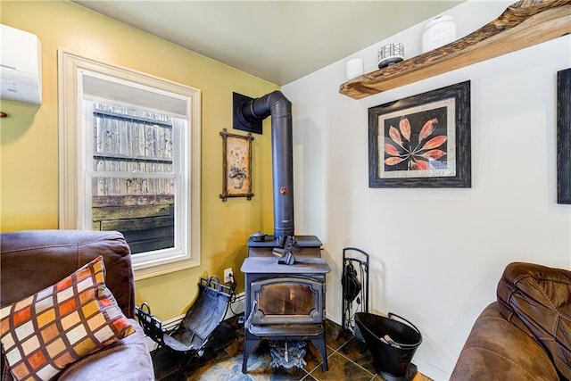 sitting room featuring baseboards, a wood stove, tile patterned floors, and a wall mounted air conditioner