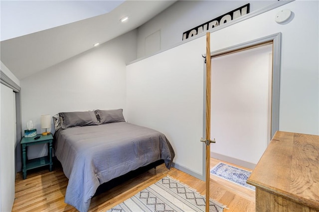 bedroom with recessed lighting, wood finished floors, and lofted ceiling