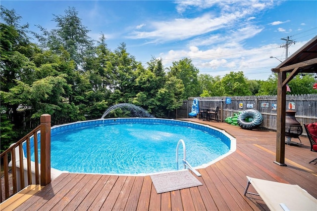 pool with a wooden deck and a fenced backyard