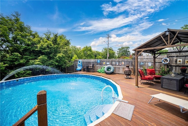 view of pool featuring a fenced in pool, a fenced backyard, a wooden deck, and a gazebo