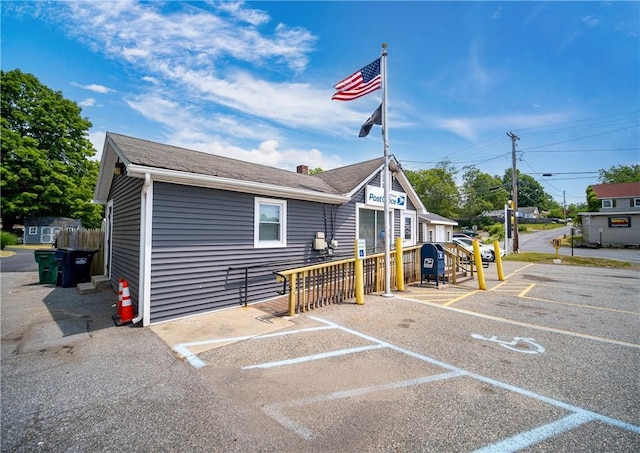 exterior space with a chimney and uncovered parking
